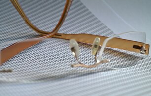 Eine Brille liegt auf einem Dokument, das über und über mit Paragrafen-Zeichen bedruckt ist.