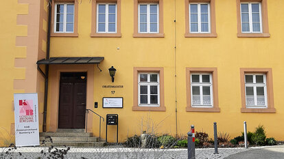 Die gelbe Außenfassade des Oblatenklosters in Kronach mit dem Eingang zum Büro des KAB Diözesanverbandes Bamberg e.V.