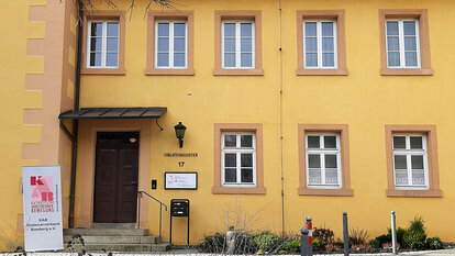 Die gelbe Außenfassade des Oblatenklosters in Kronach mit dem Eingang zum Büro des KAB Diözesanverbandes Bamberg e.V.