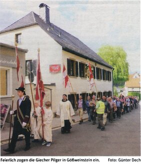Ein Zeitungsfoto zeigt eine Prozession der Giecher Pilger beim feierlichen Einzug in Gößweinstein. Angeführt wird die Gruppe von einem Mann in Festtracht mit Stab, gefolgt von Ministranten mit Kirchenfahnen, einem Geistlichen im liturgischen Gewand und einer langen Schlange von Pilgern.