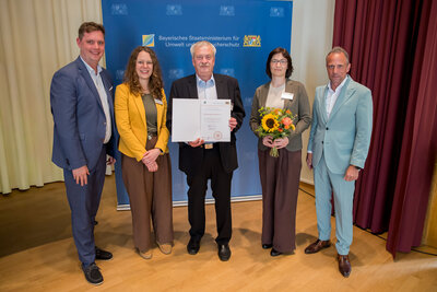 Urkundenübergabe an das KAB Bildungswerk Bamberg: Die Auszeichnung für 10 Jahre Stützpunkt Verbraucherbildung geht an das KAB Bildungswerk Bamberg; hier zusammen mit dem Minister für Umwelt- und Verbraucherschutz Bayern Thorsten Glauber (rechts im Bild) und dem 2. Bürgermeister der Stadt Bamberg Jonas Glüsenkamp (links im Bild).