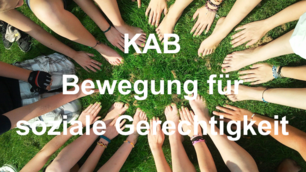 Zahlreiche Hände und nackte Füße von Jugendlichen bilden einen geschlossenen Kreis auf einer grünen Wiese, überlagert vom weißen Schriftzug „KAB Bewegung für soziale Gerechtigkeit“.
